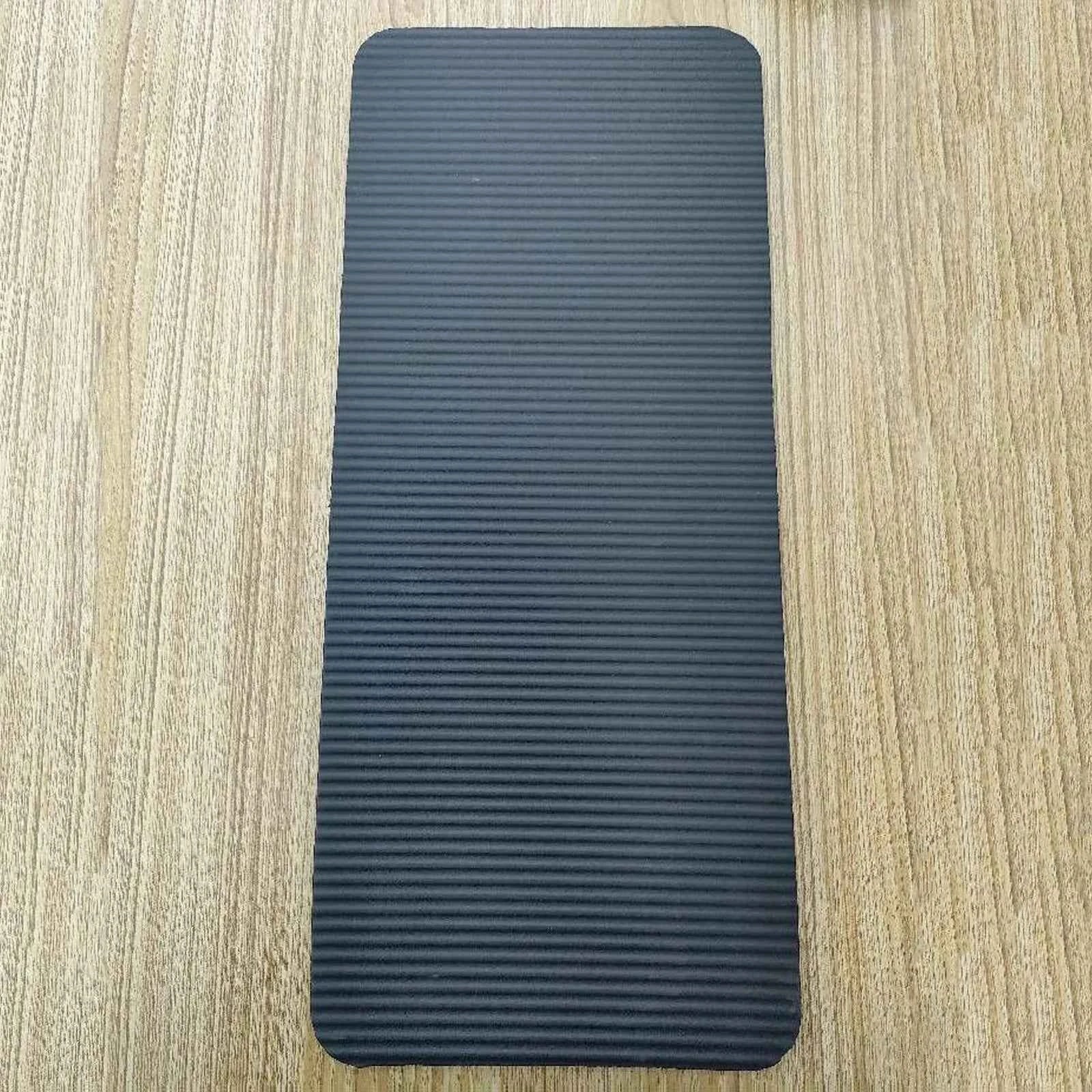 Dark gray mini yoga mat with textured anti-slip surface, compact